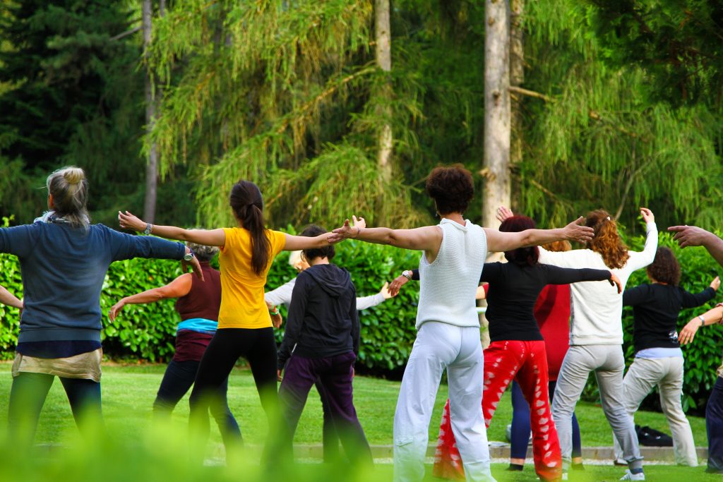 Groep mensen sporten samen in park.