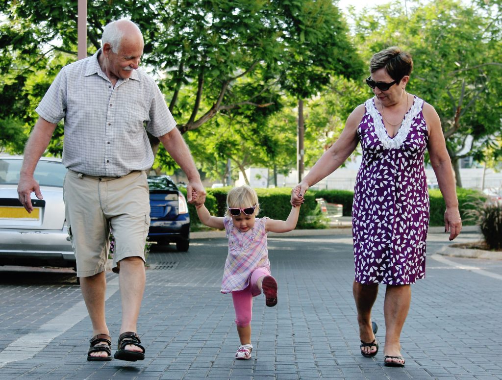 Grootouders wandelen met kleinkind.